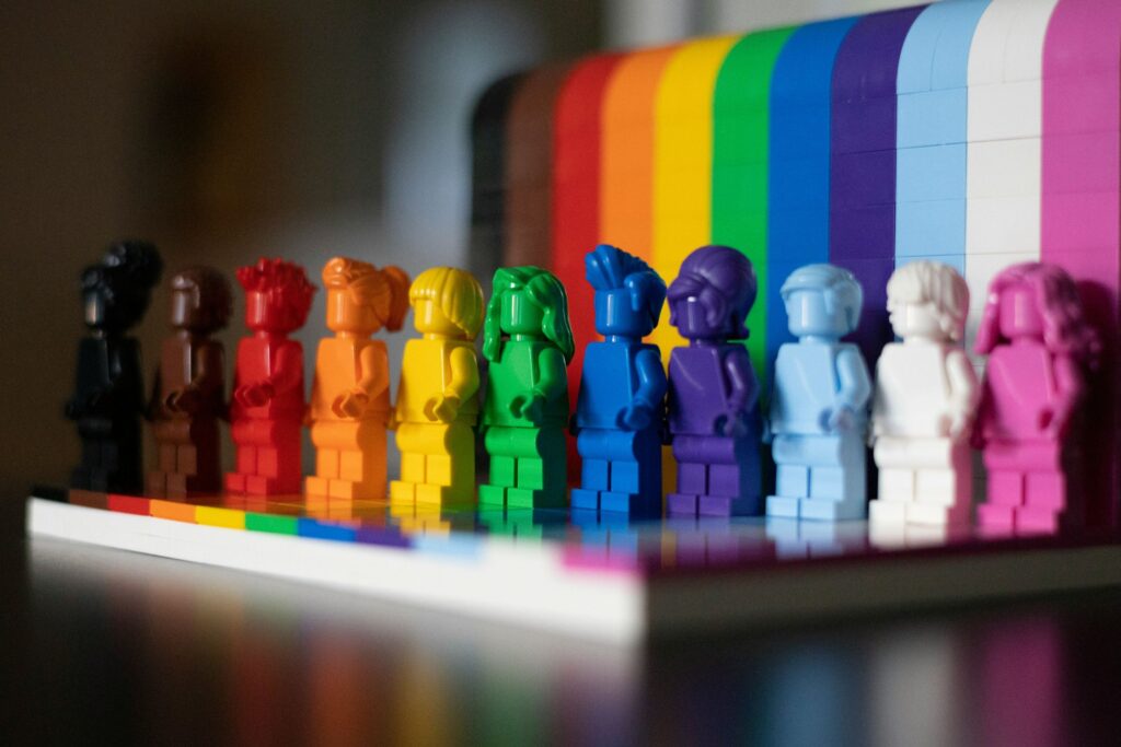 multiple lego people of different colors making a rainbow