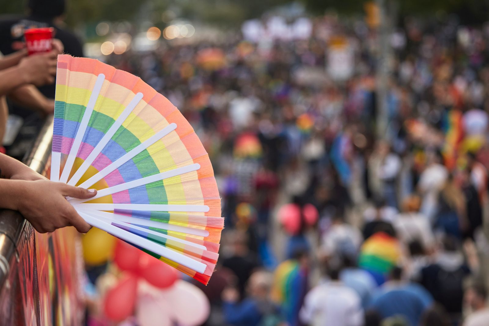 hand holding a pride fan in a flag
