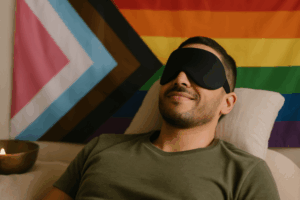 person with a blindfold on, laying in front of a pride flag